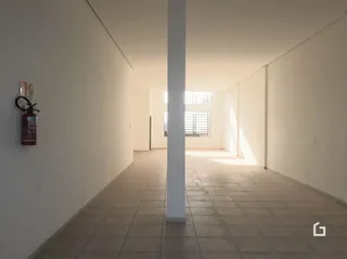 Corredor interno com paredes brancas e piso de cerâmica.