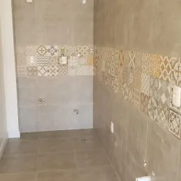 Parede interna com revestimento de azulejos decorativos em tons neutros.