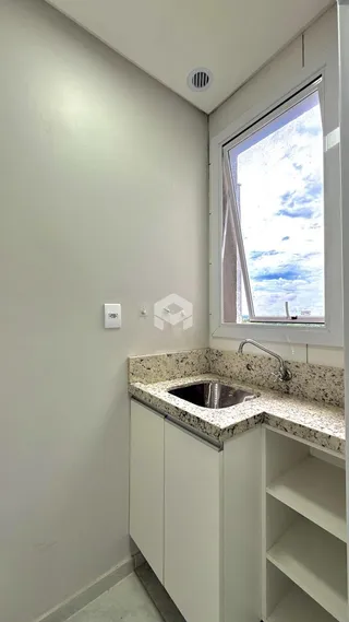 Mostra uma bancada de cozinha com pia e armários brancos.