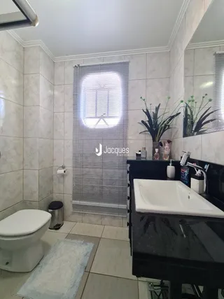Foto de um banheiro interno com piso de cerâmica e louças sanitárias.