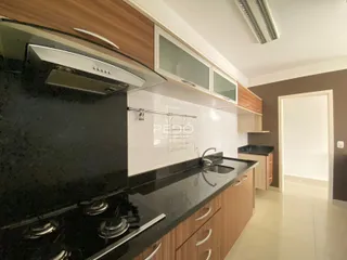 Cozinha moderna com armários de madeira e bancada escura.