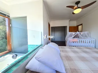 Quarto com vista e área de banho separada por vidro.