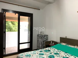 Quarto com porta de vidro abrindo para a área externa.