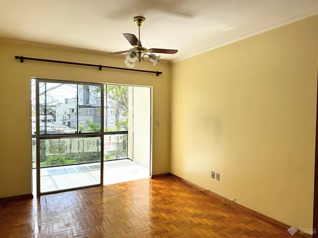 Sala de estar com piso de madeira e porta de vidro que dá para o exterior.