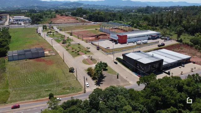 Vista aérea de uma área de terreno com campos e um complexo de edifícios industriais.