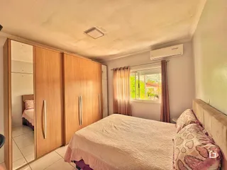 Quarto com armários de madeira e janela.