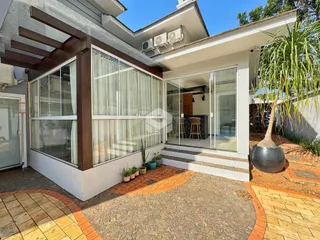 Fachada de uma residência moderna com área externa pavimentada.