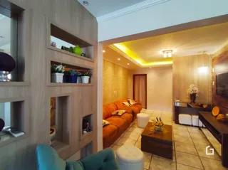 Sala de estar com painéis de madeira e móveis alaranjados.