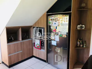 Interior com armários de madeira e geladeira em um imóvel.