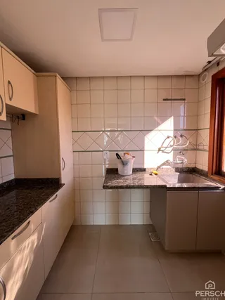 Cozinha com armários brancos e revestimento de azulejos brancos.