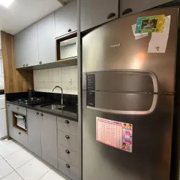 Cozinha moderna com armários cinza e eletrodomésticos de aço inoxidável.