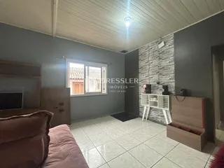Sala de estar com piso de cerâmica e parede de tijolos expostos.
