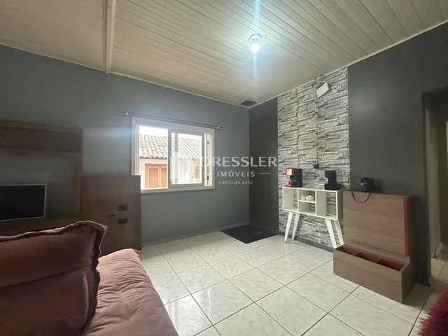 Sala de estar com piso de cerâmica e parede de tijolos expostos.
