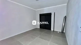 Foto de um cômodo interno com paredes brancas e piso de cerâmica.