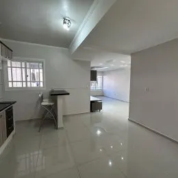 Hall de entrada com paredes brancas e piso claro.