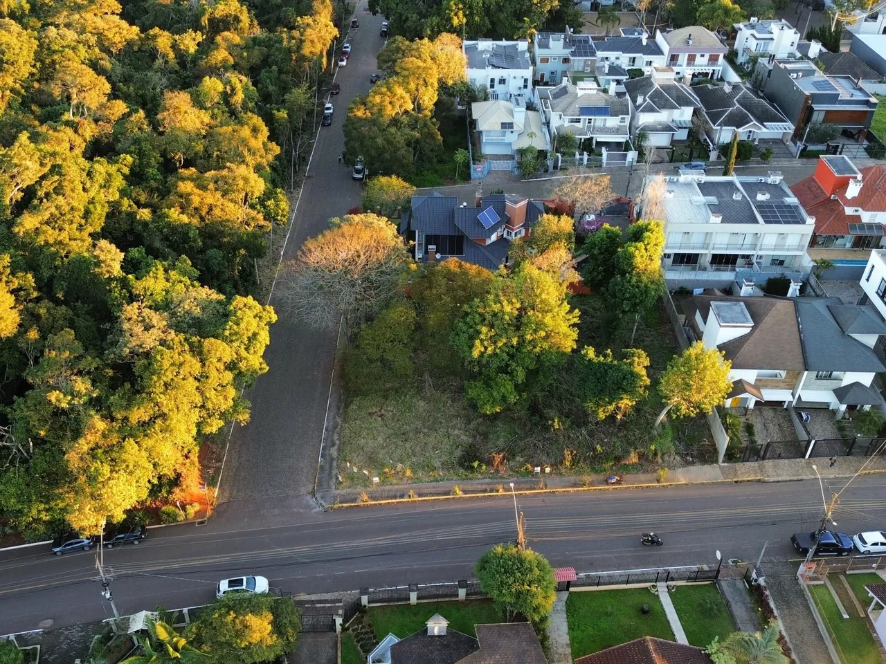 Vista aérea de uma rua residencial em Lajeado, Brasil, mostrando casas e vegetação.