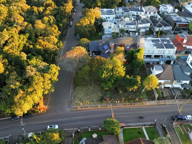 Vista aérea de uma rua residencial em Lajeado, Brasil, mostrando casas e vegetação.
