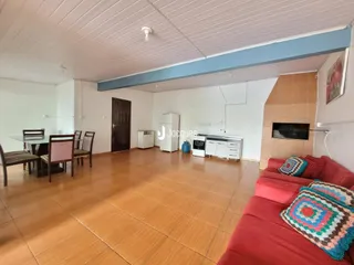 Sala de estar com mesa de jantar e sofá em um imóvel no Brasil.