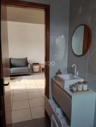 Vista de um interior mostrando uma transição entre uma sala de estar e um banheiro.