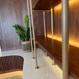 Hall de entrada com painéis de madeira e iluminação quente.
