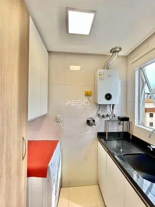 Parede interna com revestimento cerâmico e instalação de um aquecedor de água.