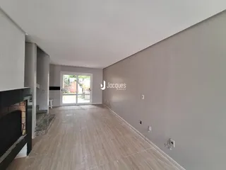 Corredor interno com piso claro e parede cinza.