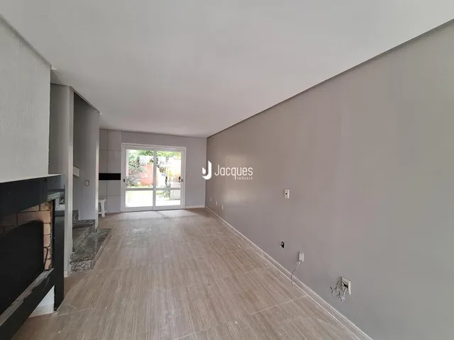 Corredor interno com piso claro e parede cinza.