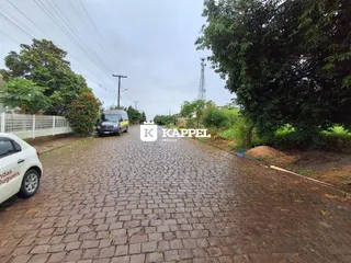 Vista externa da entrada de uma propriedade em Lajeado, Brasil, mostrando uma estrada pavimentada.