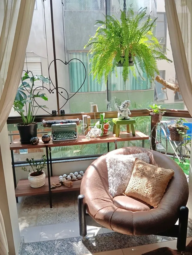Vista da varanda com plantas e uma poltrona de couro.