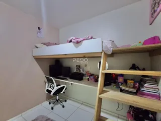 Quarto com estantes de madeira e cama no interior da residência.