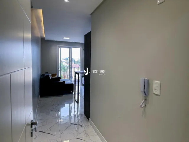 Hall de entrada com piso de mármore polido e paredes claras.