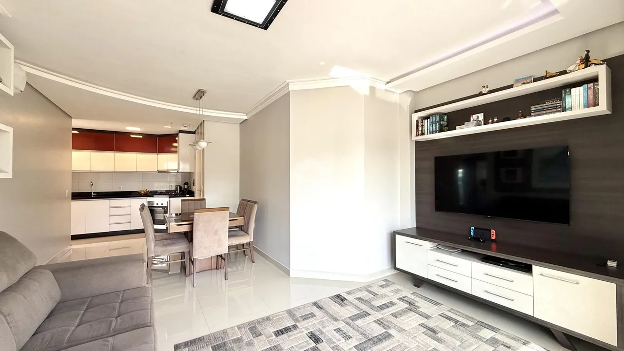 Sala de estar com cozinha e área de jantar em um apartamento.