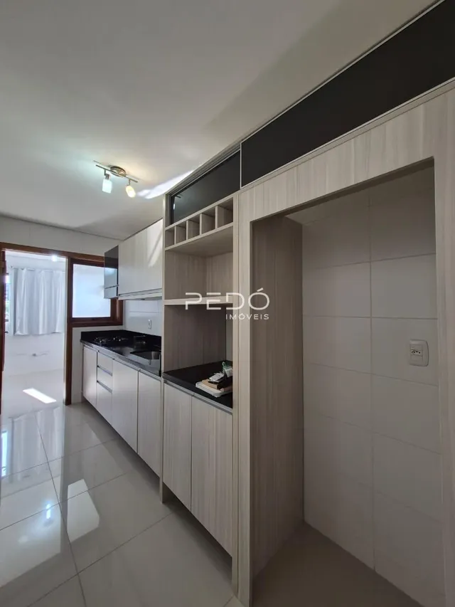Foto de uma sala de estar com armários embutidos e piso claro.