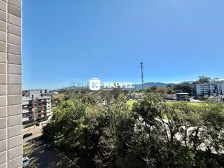 Vista panorâmica da paisagem com vegetação e edifícios ao fundo.