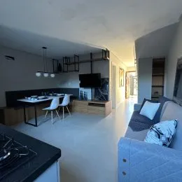 Sala de estar com mesa e televisão em um ambiente interno.