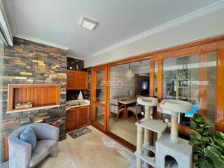 Sala de estar com parede de pedra e detalhes em madeira.