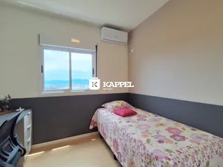Quarto com cama e janela mostrando a vista externa.