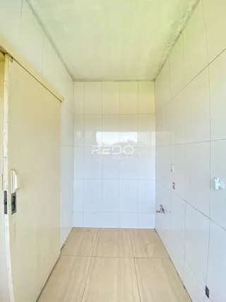 Corredor com paredes brancas e piso claro de cerâmica.