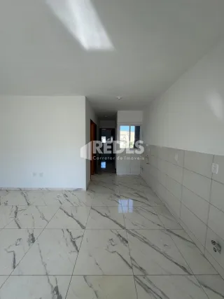 Corredor interno com piso de mármore branco.