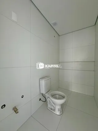 Foto de um banheiro com paredes brancas e um vaso sanitário.