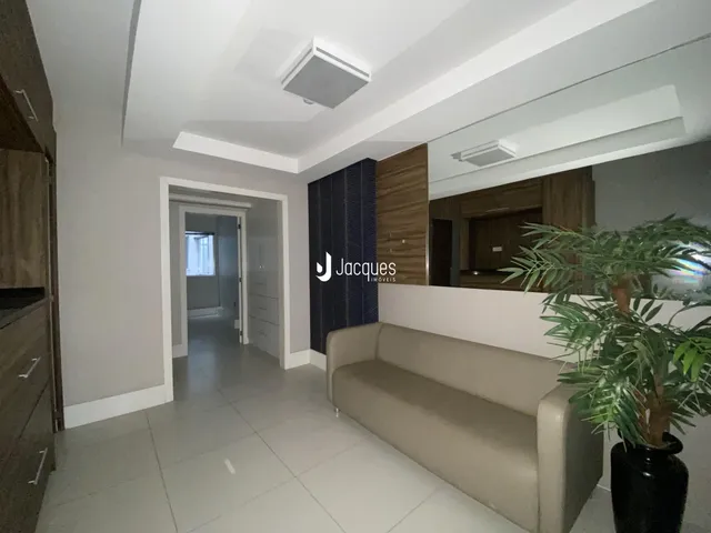 Ambiente interno de uma sala com sofá e piso claro.