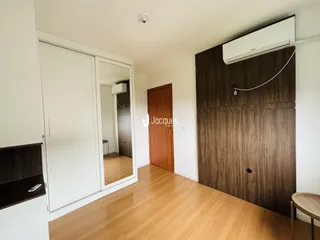 Quarto com piso de madeira e armário de madeira na Lajeado, Brasil.