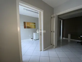 Vista de um corredor interno com portas abertas em uma residência.