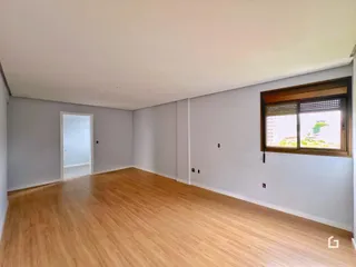Ambiente interno com piso de madeira e paredes brancas.