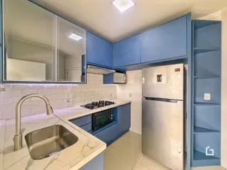 Foto de uma cozinha moderna com armários azuis e bancada clara.