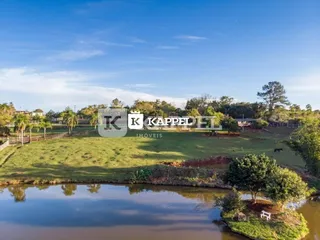 Vista de um corpo d'água com vegetação verde em uma área externa.