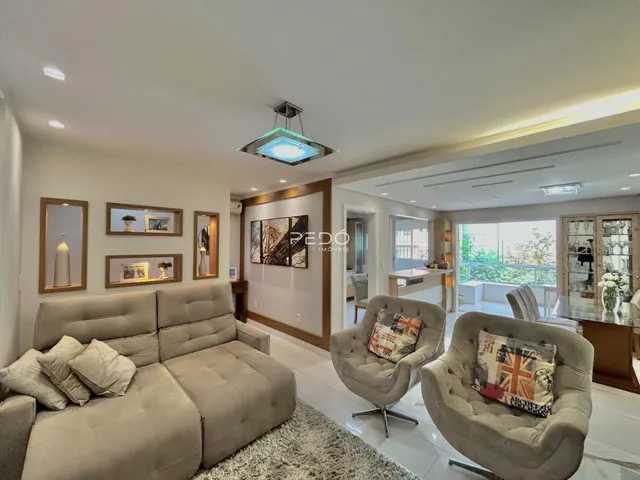 Sala de estar moderna com sofá e poltronas em um ambiente claro.