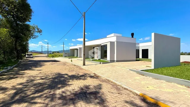 Foto da fachada moderna de uma casa branca em Lajeado, Brasil.