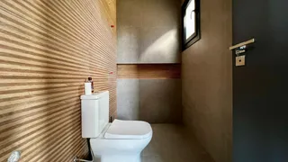 Banheiro com revestimento de parede listrado e vaso sanitário branco.