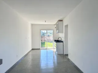 Hall de entrada com piso de cerâmica e paredes brancas.